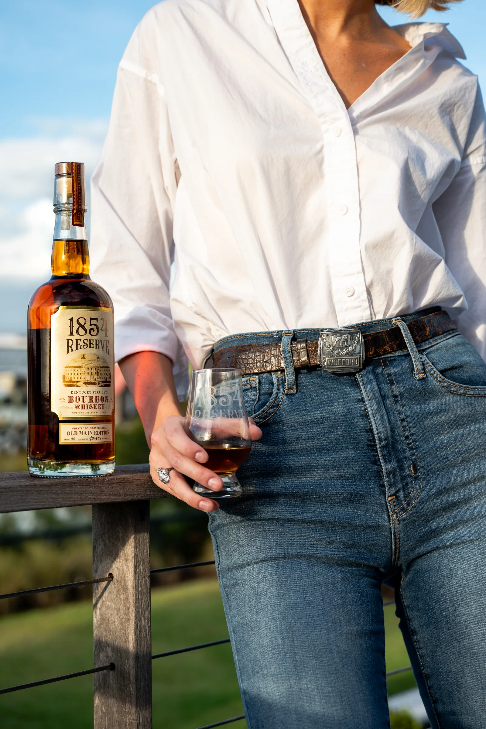 Person enjoying a glass of 1854 Reserve bourbon